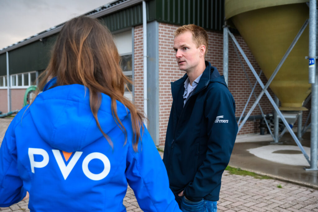 Medewerker van PVO in gesprek met een boer op een boerenerf